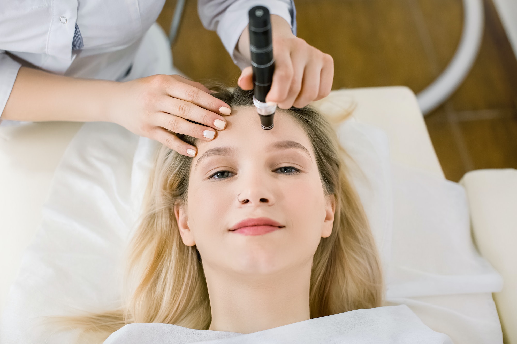 Dermatology and cosmetology clinic cropped top view of face of pretty blond woman during skin.jpg